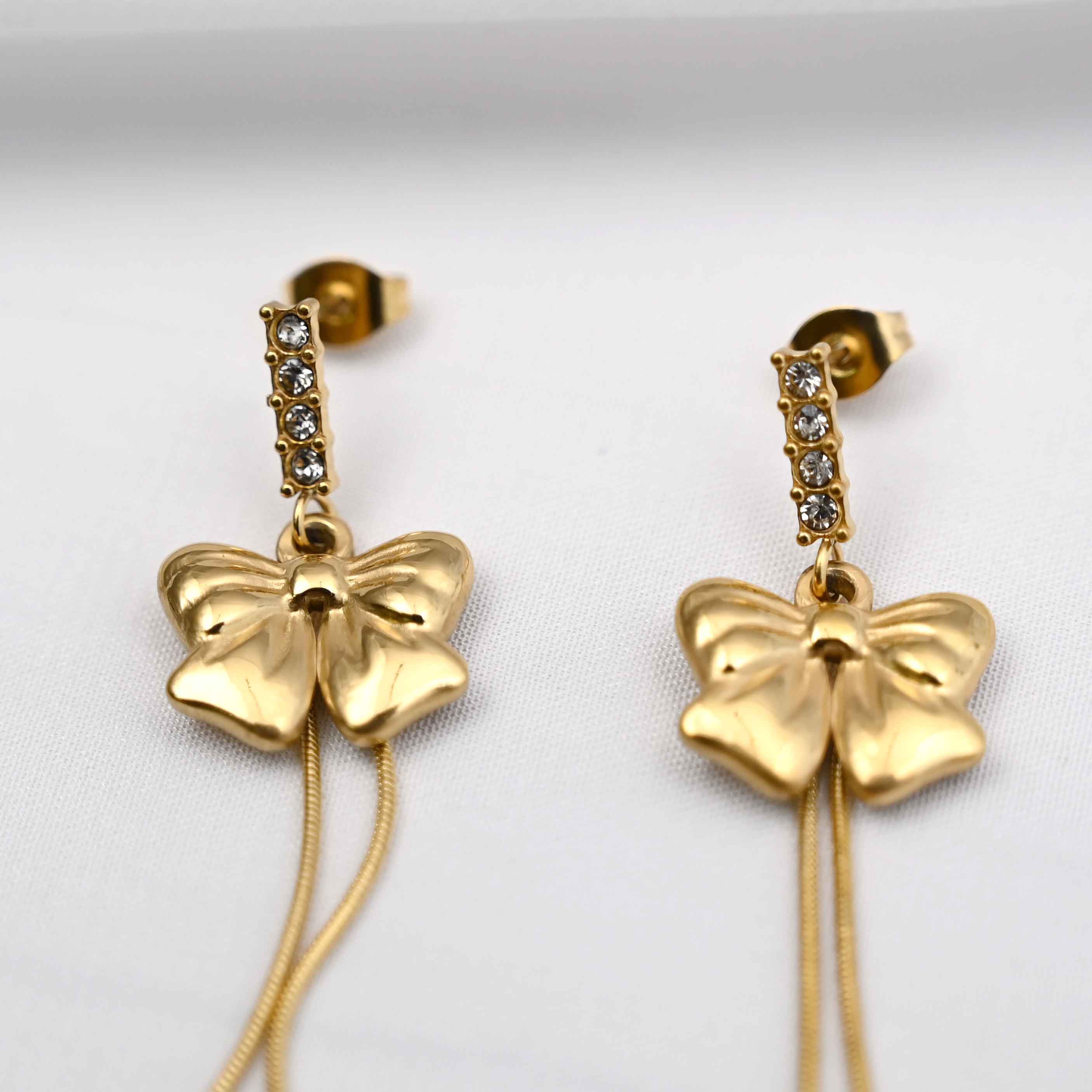 Dangling bows earrings in gold